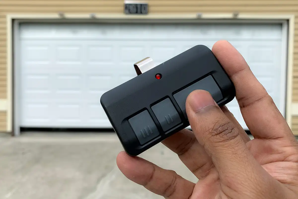Tri County Garage Door Company—A homeowner’s hand holds a garage door opener but the garage door isn’t opening at his home in Edwardsville, IL.